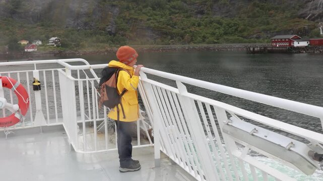People, enjoying ferry ride between Bodo and Lofoten Moskenesoya summertime, child and adults on a ferry on sunset