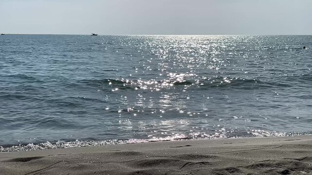 Sun reflection on sparkling sea water background beautiful sunny day at sandy beach.