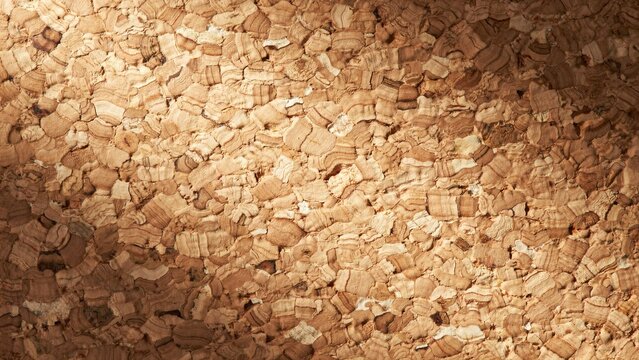 Natural cork granules texture background, organic brown wood chips mulch for sustainable gardening, recycled cork bark pieces for insulation and craft projects.