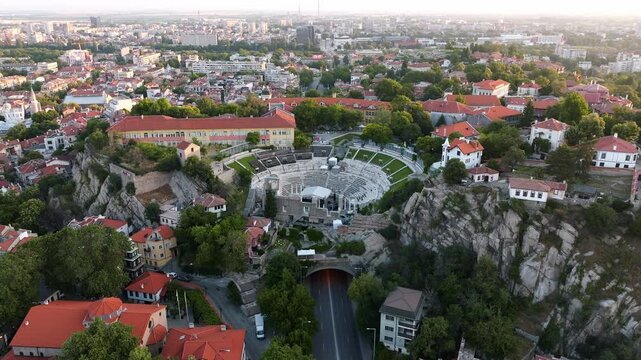 Aerial top view ancient Roman theatre old town Plovdiv tunnel road red tiled roofs cityscape sunrise warm light travel destination Bulgaria Europe