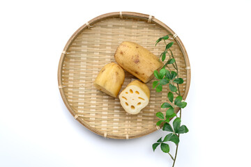 竹ざるに盛った新鮮なれんこんと断面 © Wakko