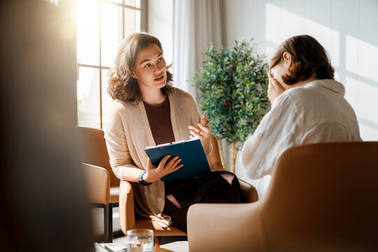 Professional Therapist Consulting with Emotional Client in Modern Office