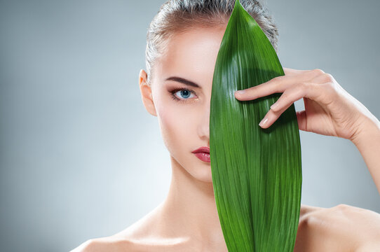 Natural Beauty Woman with Green Leaf for Skincare and Wellness Concept
