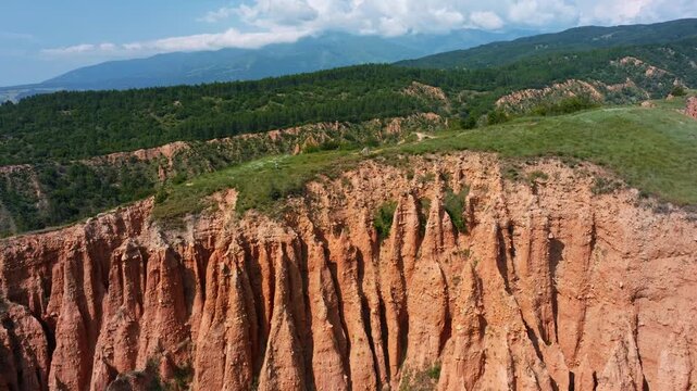 Aerial view Stob Pyramids earth pyramids sandstone rock formations green hills background sunny daylight summer hiking trail travel destination Rila Bulgaria