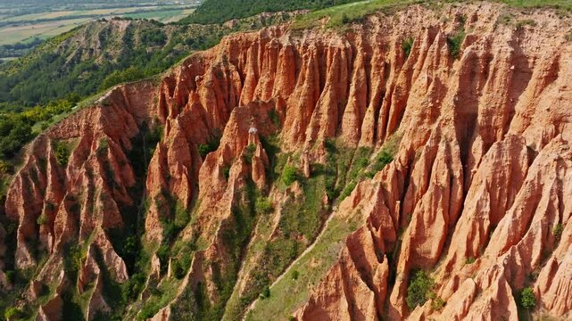 Aerial top view Stob Pyramids erosion sandstone clay cliff formations green vegetation sunny day summer hiking trip travel destination Rila region Bulgaria