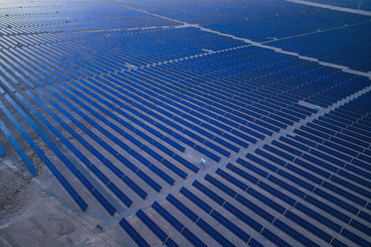 Solar photovoltaic panels at sunrise/sunset; wind turbine power plant; new energy