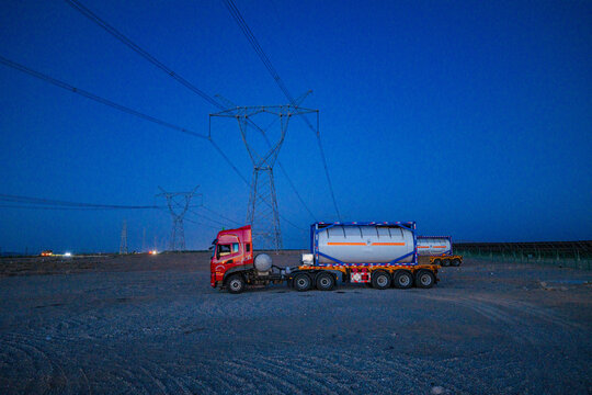 High-voltage power transmission tower at dusk