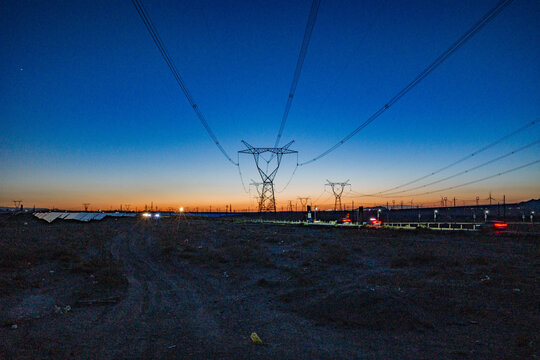 High-voltage power transmission tower at dusk