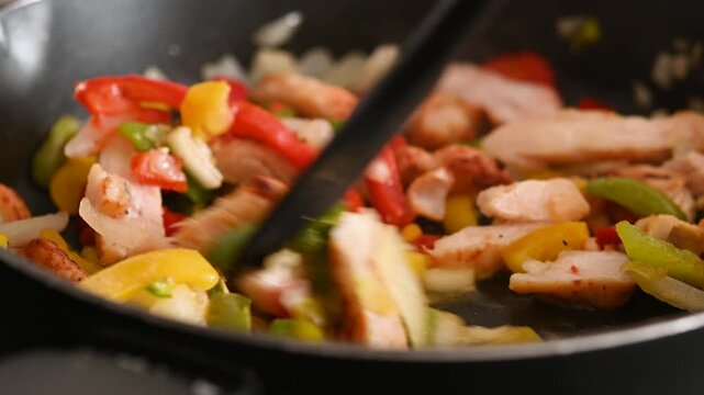 Cooking chicken fajitas with peppers and onion. Close up
