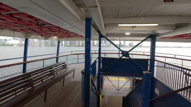 POV walk along the upper deck of a moving Toronto Island ferry, gradually revealing a wide unobstructed view of the Toronto skyline across Lake Ontario.