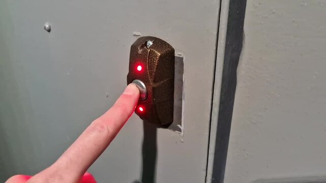 Hand activating indoor release button to open intercom door