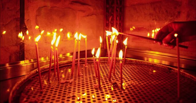 Female hand lighting candles at a Religious Temple