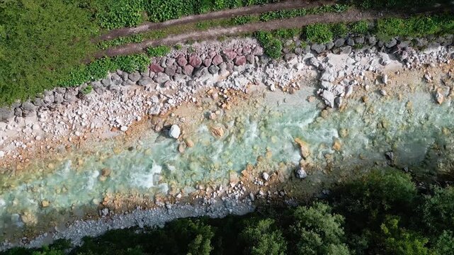 Triglavska Bistrica. Top-down drone video following a turquoise mountain stream as it winds through dense forest in the Julian Alps of Slovenia