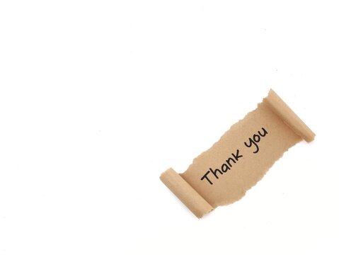 Handwritten thank you text on a piece of torn brown kraft paper scroll, isolated on white background wiyh copy space. Minimalist gratitude note concept for business and customer appreciation