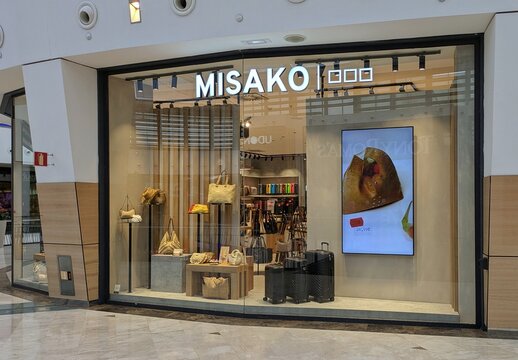 Escaparate con maletas, bolsos y accesorios en estantes, con una pantalla digital, en tienda de moda femenina Misako en Madrid, Espa&ntilde;a, 14 de junio de 2026