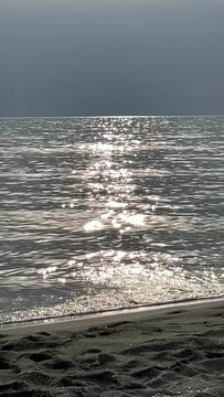 Golden sun reflection on sparkling sea water background.
