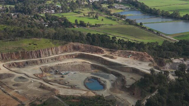 Melbourne, VIC, Australia - 20 August 2026: Aerial view of a quarry with excavation pits, a small pond, and surrounding rural landscape.
