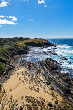 Vertical aerial view of the rugged headland and rocky coastline at Brooms Head on the NSW North Coast, featuring exposed coastal rock formations, Pacific Ocean and native vegetation 