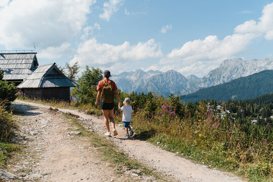 Mother and child admiring a stunning mountain landscape together during a summer hike.