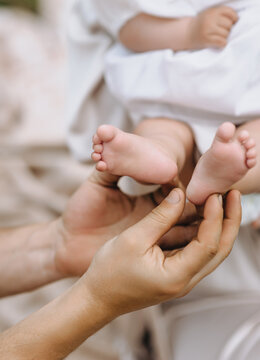 A close-up photo of a father holding his baby's tiny feet. Concept of fatherhood.
