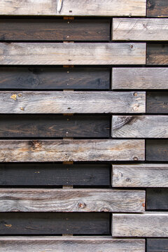 Rustic wooden wall texture with alternating dark and light weathered planks, creating a modern patte