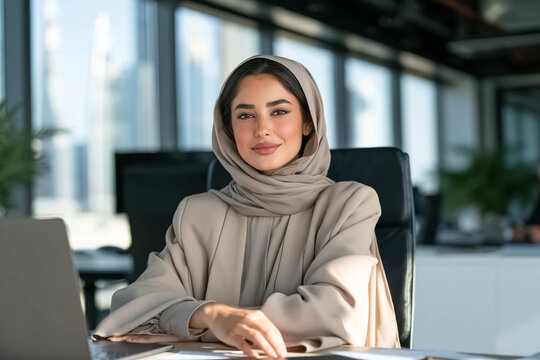 Confident Emirati businesswoman wearing elegant hijab in a modern office, professional leadership and women's empowerment concept