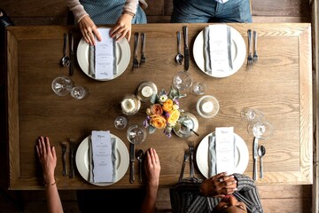 Obraz premium Top view of a dining table set for four with menus and floral centerpiece.