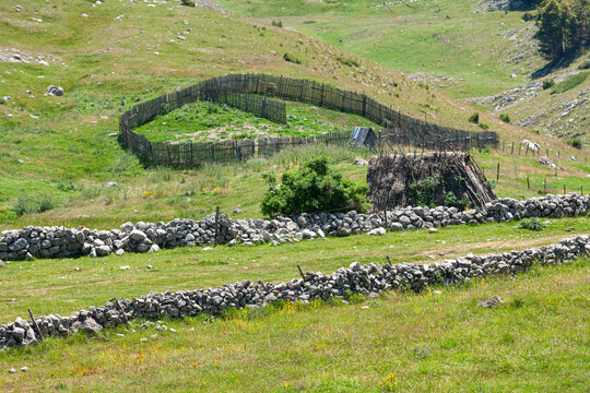 Zabljak, Zabljak Municipality, Montenegro - 30 July 2005: View of a traditional wooden fence and stone walls in the rural landscape of Durmitor National Park.