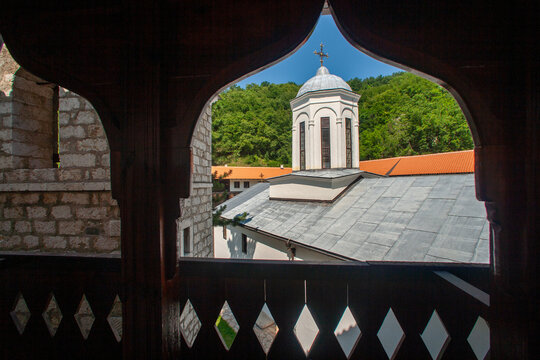 Pljevlja, Pljevlja Municipality, Montenegro - 30 July 2005: View of the Holy Trinity Monastery seen from a wooden balcony, featuring its dome, stone walls, and lush green trees.