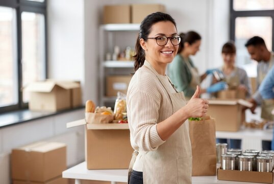 Young woman volunteering, sorting donations for community service with a team