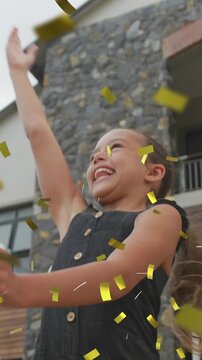 Animation of gold confetti over celebrating caucasian schoolgirl throwing mortar board in air
