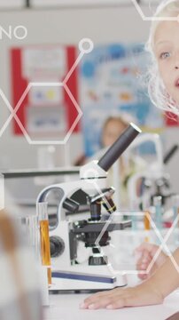 Animation of elemental diagrams over smiling caucasian schoolgirl using microscope in science class