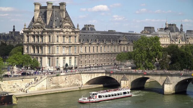 Elevated camera shot of Seine River with vintage bridge and neoclassical architecture in 1st arrondissement of Paris.