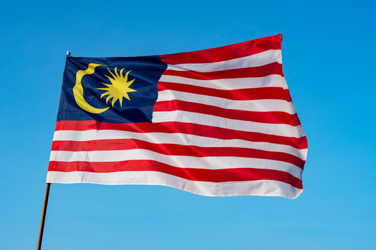 Malaysian flag against blue sky with copy space