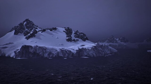 Aerial snow island under rare light, soft glow breaking through storm clouds, reflective sea margins, thaw hints and scattered ice, calm mood with hopeful