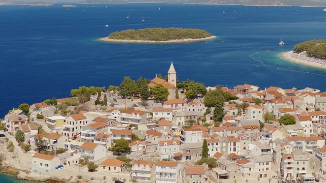 Aerial drone view of the historic town of Primo&scaron;ten in Croatia, with a smooth orbital camera movement revealing red rooftops, turquoise bays, rocky coastline, surrounding islands and the Adriatic Sea.