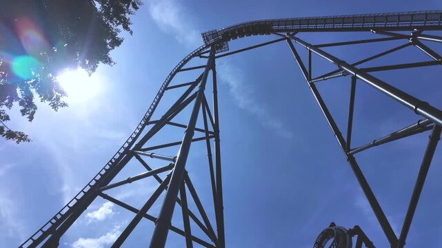 Large Steel Roller Coaster with Loops at Amusement Park on Sunny Day