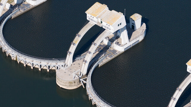 Aerial view of the Waterkrachtcentrale Maurik hydroelectric power station with its curved dam structure and industrial architecture on the river in Maurik, Gelderland, Netherlands.