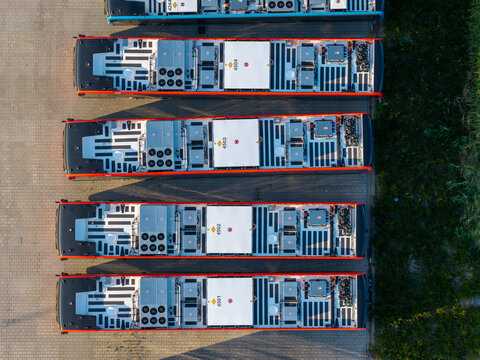 Aerial view of electric buses parked at the EBS Public Transportation BV charging station, showing vehicle roofs with charging equipment in Purmerend, North Holland, Netherlands.