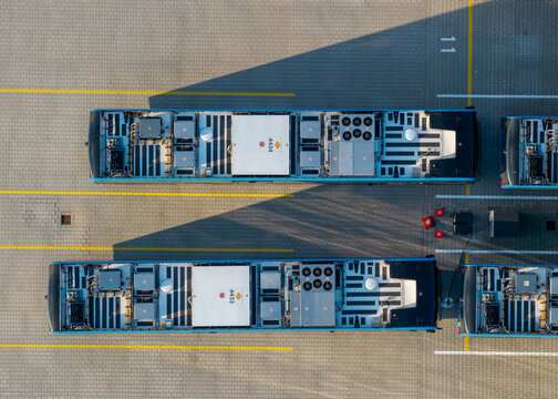Aerial view of electric buses parked at the EBS Public Transportation BV depot with charging equipment visible on the roofs in Purmerend, North Holland, Netherlands.