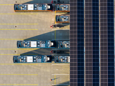 Aerial view of electric buses parked at the EBS Public Transportation BV charging station with solar panels on the roof in Purmerend, Noord-Holland, Netherlands.