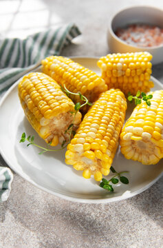 Boiled sweet corn on the cob serving with fresh herbs