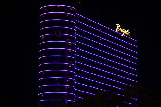 Borgata Hotel and casino in Atlantic City illuminated at night with purple and gold neon lighting, showing high-rise resort signage and urban nightlife atmosphere. 