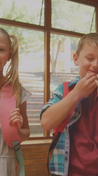 Animation of glowing light over smiling diverse school children in classroom
