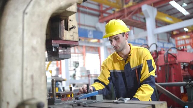 Industrial engineer in safety gear operates manufacturing machinery during a factory audit, quality control inspection, and production process.