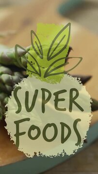 Superfoods text animation over fresh asparagus on wooden cutting board