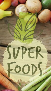 Super foods text animation over various fresh fruits and vegetables on wooden surface