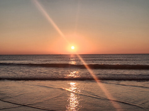 Walking near beautiful sea in the evening and view on the sunlight. Sunset on the beach in summer time. Vacation in Ostend, Belgien. Nature background.