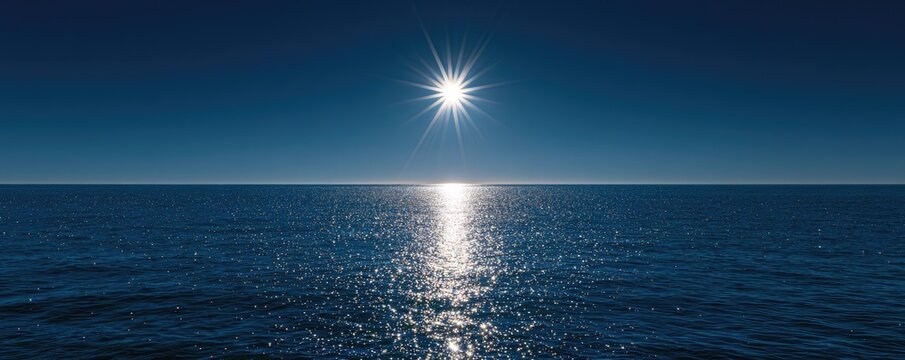 Sun glitters on the endless blue ocean under a clear, dark sky