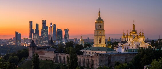 Fototapeta premium St. Michael’s Golden-Domed Monastery and modern skyline at sunset in Kyiv, Ukraine